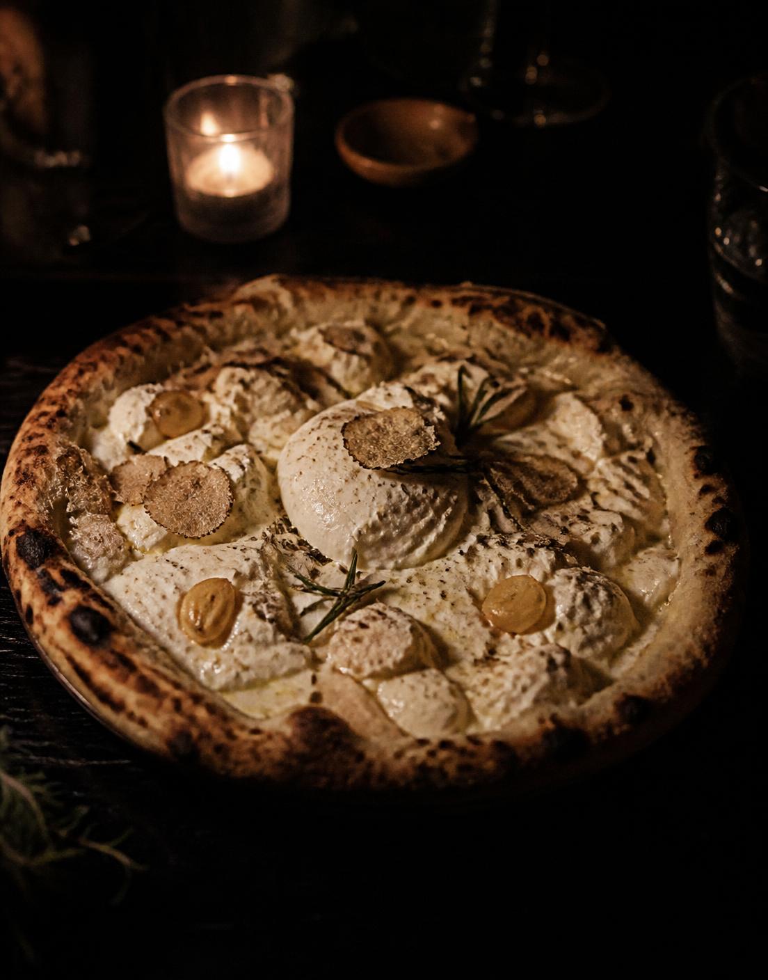 Pale white pizza with burrata, whipped ricotta, garlic confit and shaved white truffle